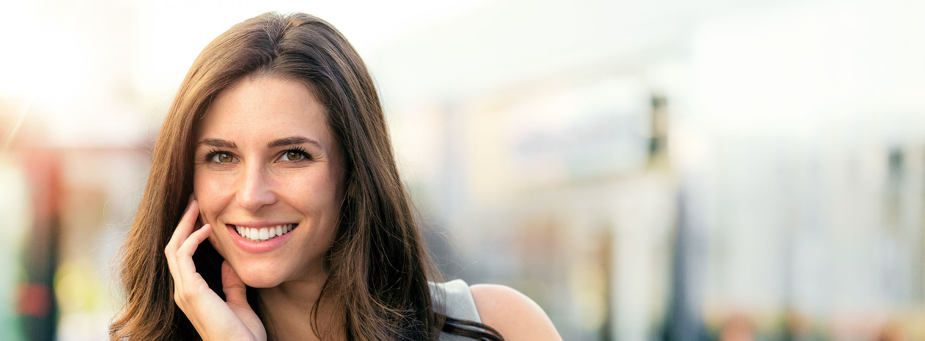 A smiling woman with brown hair and a black top, looking directly at the camera.