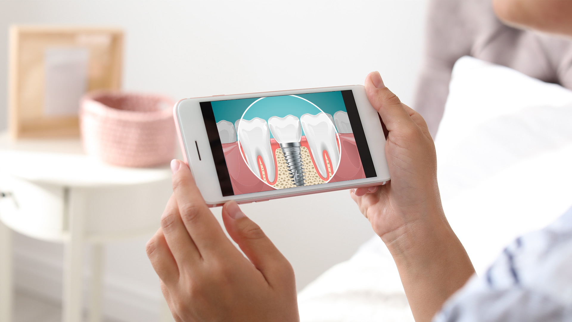 The image shows a person holding a smartphone displaying an illustration of teeth with a magnified view of the gumline, possibly indicating dental health or oral care.