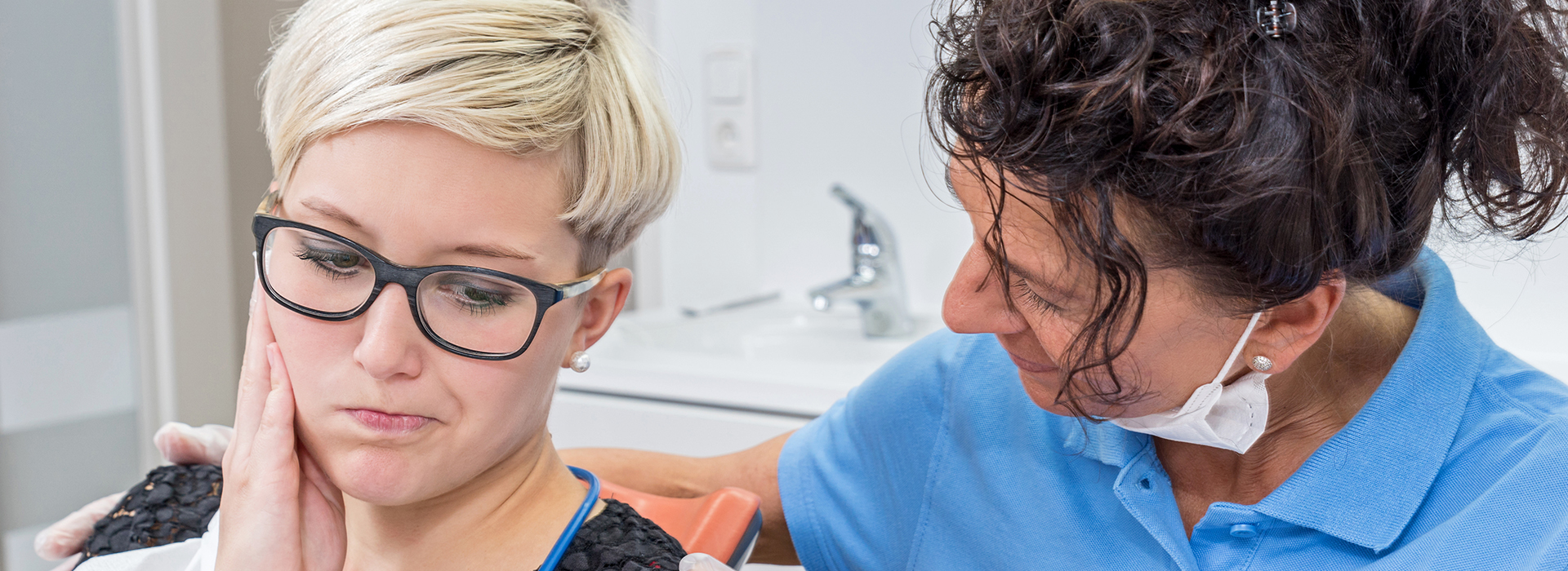 The image features a woman in a dental chair receiving dental care from a professional, with a clear focus on the dental work being performed.