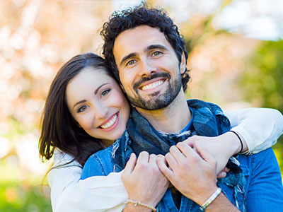 A man and a woman smiling at the camera, posing for a portrait.